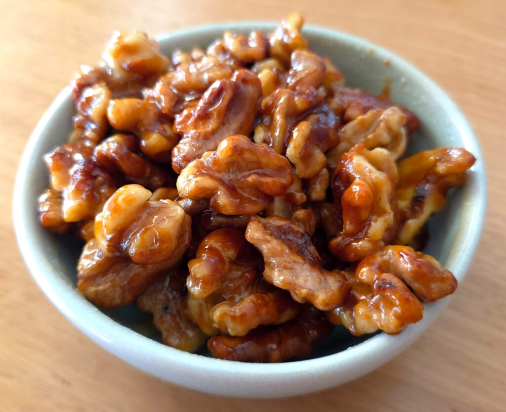 Close-up photo of the candied walnuts to show how glossy and caramelised they become in the caramel/toffee
