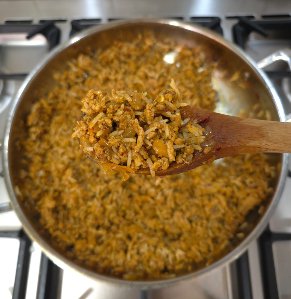 Close-up photo of the rice and meat mixture, showing how fatty and rich the pork makes the dish